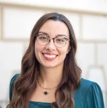 This is a photo of Andreina Sanchez Collado.  She has medium complexion and brown hair, and she is wearing a dark green shirt.