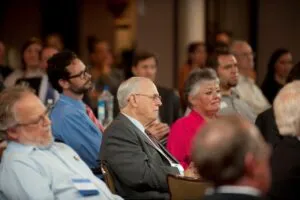 This is a picture of an audience at an event at the UT Library. Ray Marshall is in the center.