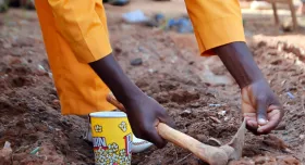 This is the report cover for Nuru Burkina Faso 2023 Impact Report.  It shows a person planting seeds.