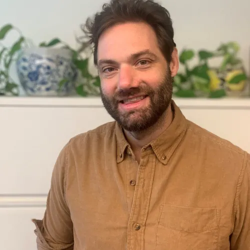 This is an image of David McCoy, a Social Science Research Associate at the Ray Marshall Center at the University of Texas at Austin.  He has a light complexion, dark brown hair and beard, and is smiling.